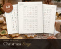 Christmas Bingo printable from Rooted & Refined: cover preview with the printed pages styled on a table