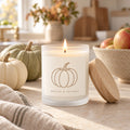 Pumpkin frosted glass candle with wooden wick lit with pumpkins and apples on a fall table