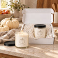 Pumpkin candle gift set: open gift box and a lit candle with white pumpkins on a fall table
