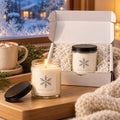 Snowflake candle gift set: open gift box and a lit candle by a snowy winter window