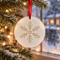 Frosted acrylic ornament with a champagne gold snowflake hanging on a frosted tree by a snowy window