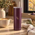 Deep fig tumbler with a champagne R&R monogram on a stone counter beside a latte and olive branches