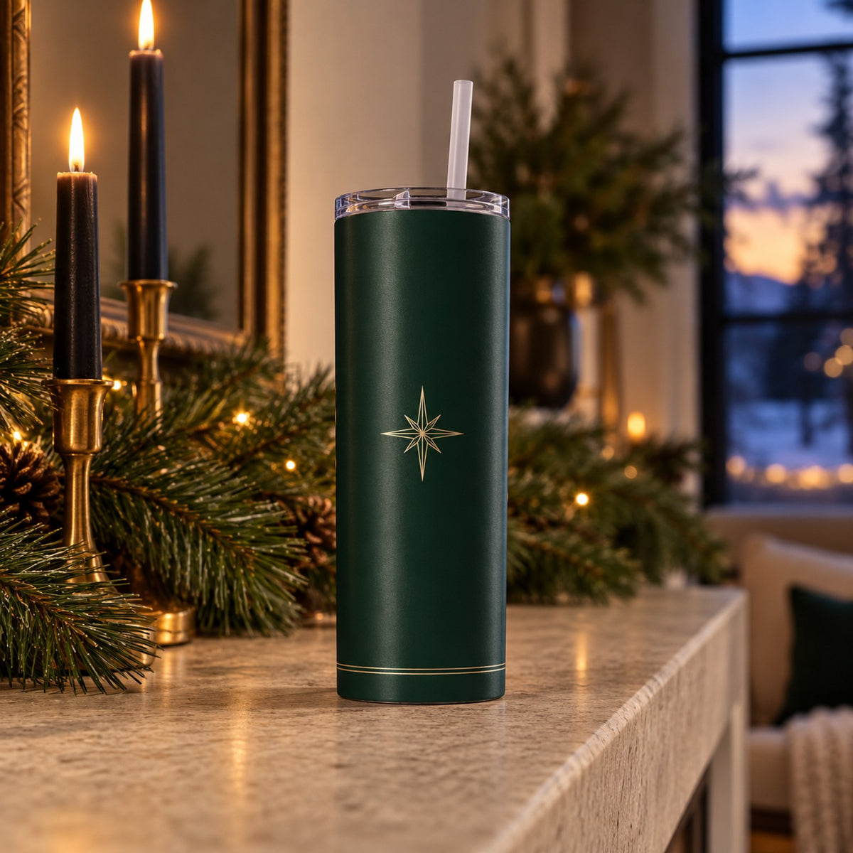 Pine green tumbler with a champagne north star on a stone mantel with brass candlesticks and greenery