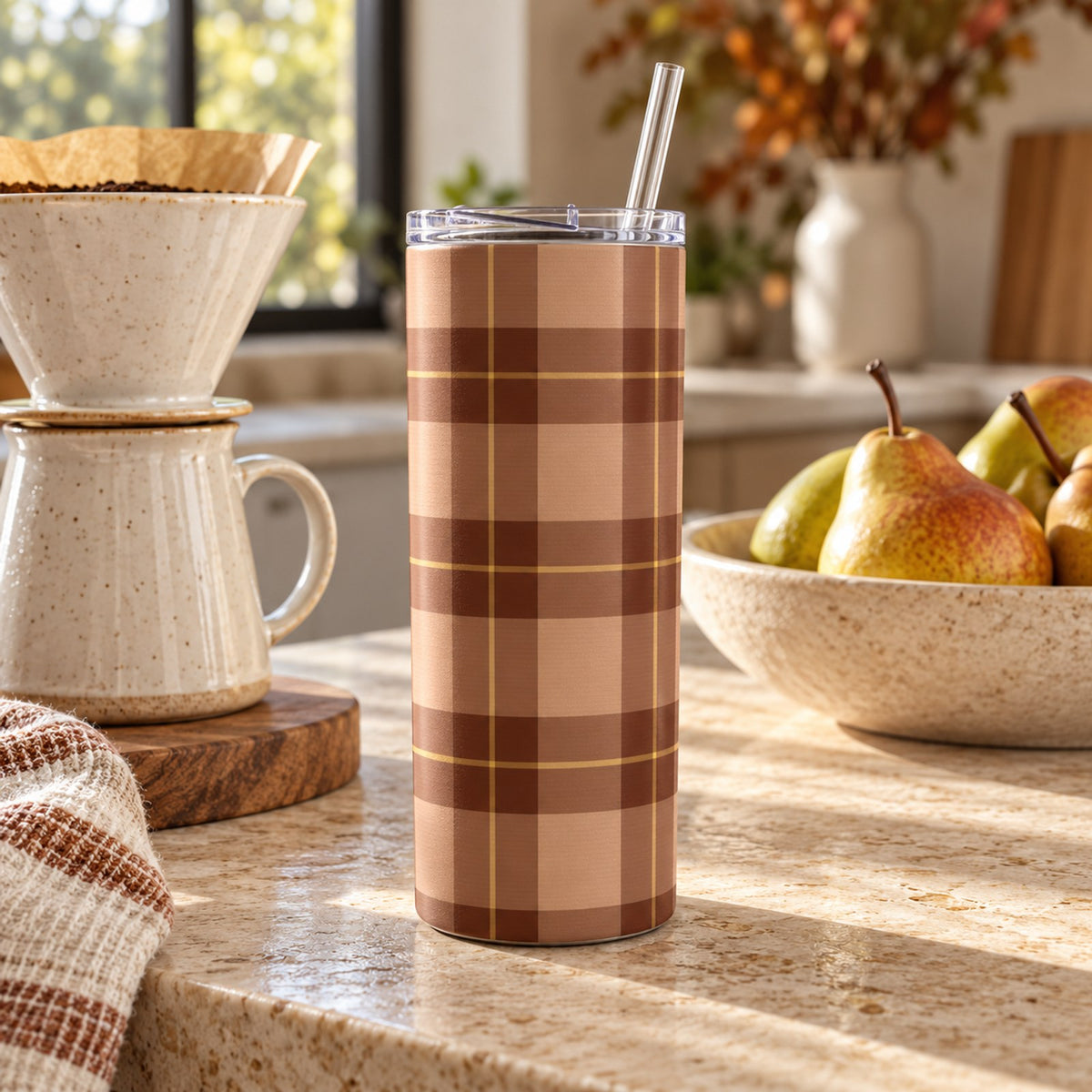 Rust and camel buffalo check tumbler on a kitchen counter with a pour-over coffee set and a bowl of pears