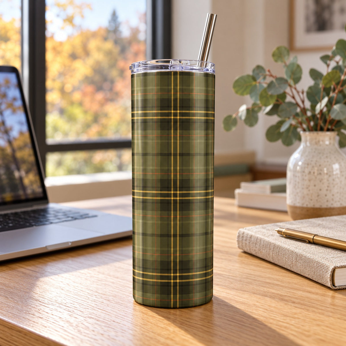 Olive and gold tartan 20 oz tumbler on a wooden desk beside a laptop, notebook and eucalyptus