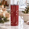 Cranberry winter berry tumbler on a marble counter with wrapped gifts, pine and a mug of cocoa