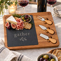 Acacia and slate charcuterie board engraved with gather, with figs, prosciutto, brie and three cheese knives
