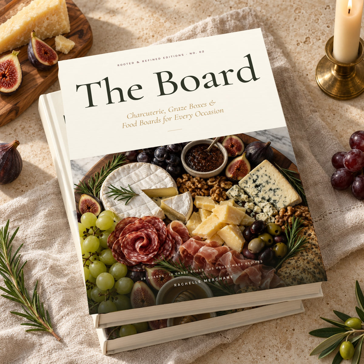 The Board: Charcuterie, Graze Boxes & Food Boards hardcover cookbook by Rachelle Merchant, two copies stacked on linen