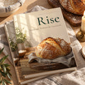 Rise: Sourdough, Without the Guesswork hardcover cookbook by Rachelle Merchant, two copies stacked on linen