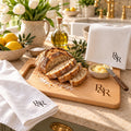 R&R Monogram Baker's Kitchen Gift Set by Rooted & Refined: engraved wood cutting board with the matching tea towel and waffle towel on a kitchen counter