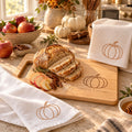 Pumpkin Baker's Kitchen Gift Set by Rooted & Refined: engraved wood cutting board with the matching tea towel and waffle towel on a kitchen counter