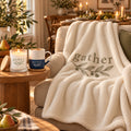 Gather Olive Branch Cozy Night In Gift Set by Rooted & Refined: sherpa throw draped on a chair with the frosted candle and engraved mug beside it