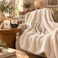 R&R Monogram Cozy Night In Gift Set by Rooted & Refined: sherpa throw draped on a chair with the frosted candle and engraved mug beside it