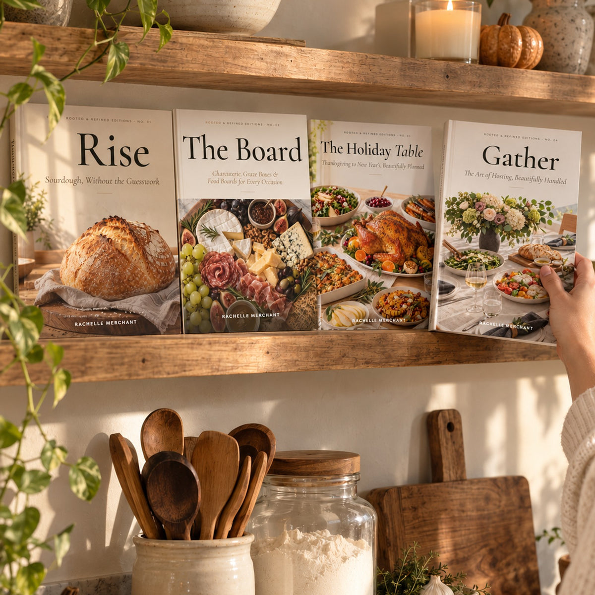 The Rooted & Refined Editions — Paperback Collection: Rise, The Board, The Holiday Table and Gather by Rachelle Merchant on a kitchen shelf