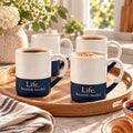 Life. Beautifully Handled. Engraved Mug Set of 4 by Rooted & Refined: four navy blue speckled mugs styled together