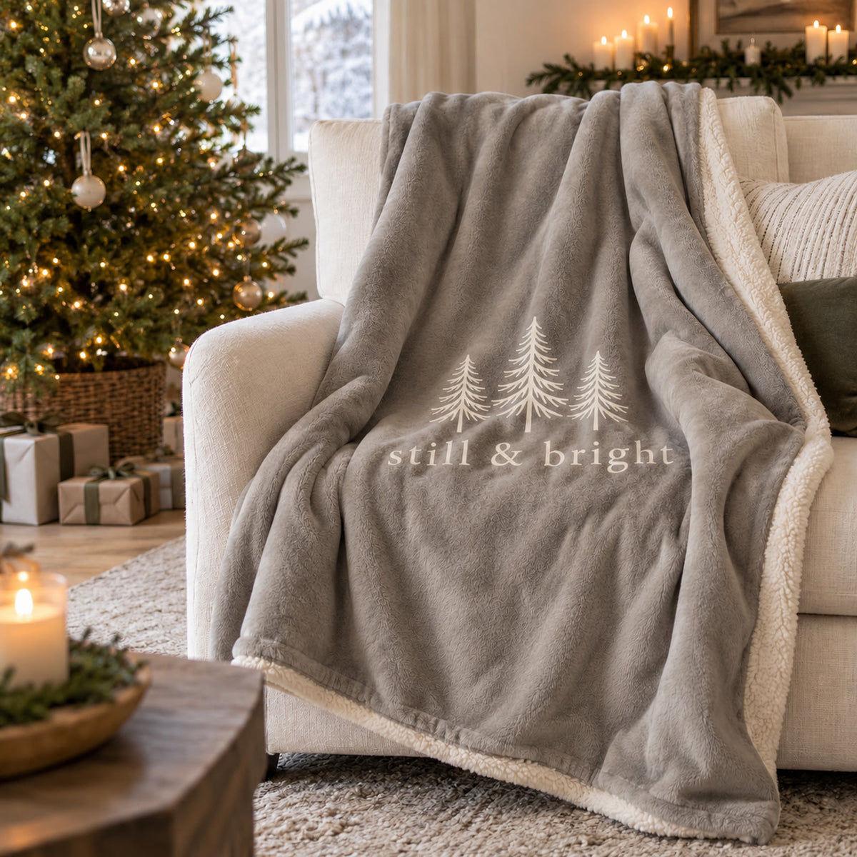 Still & Bright Evergreen Sherpa Fleece Blanket in Warm Grey by Rooted & Refined, draped over an armchair by the Christmas tree