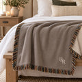 Small R&R Monogram Woven Throw Blanket in Warm Grey, styled at home
