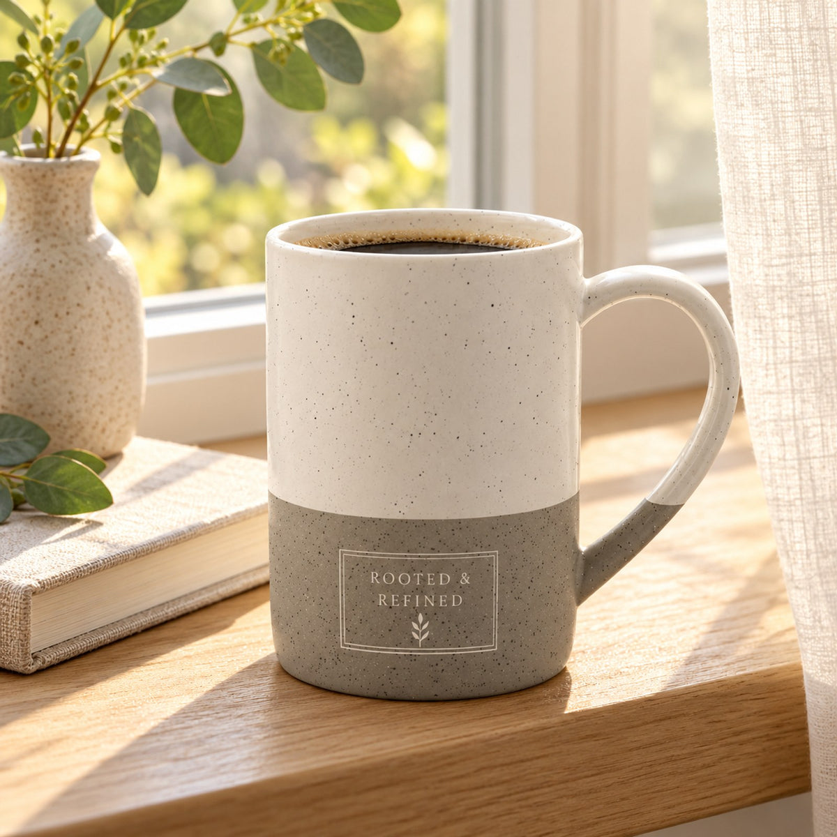 Rooted & Refined Atelier Label engraved speckled mug in Grey on a sunny windowsill