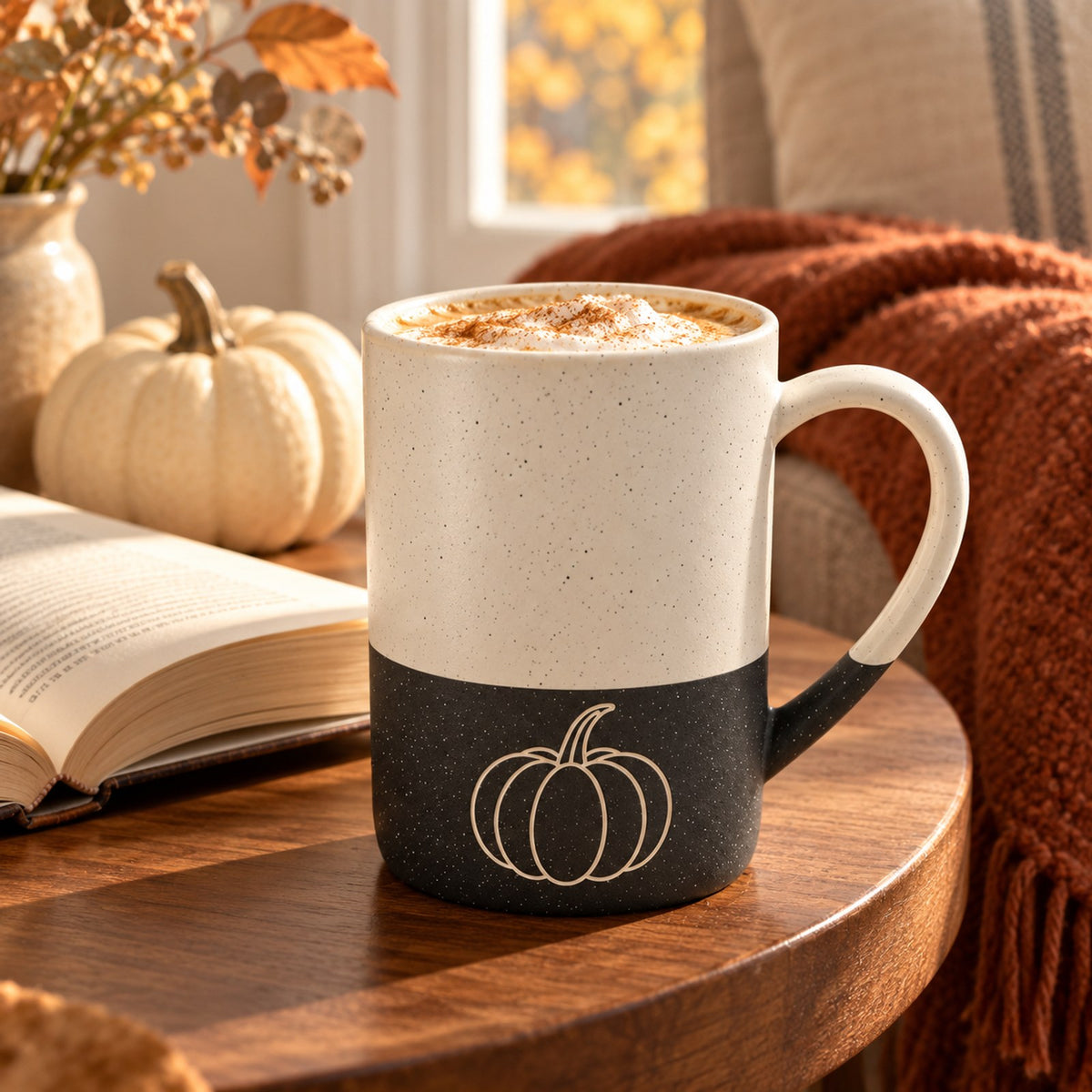 Pumpkin engraved speckled mug in Black in an autumn reading nook