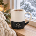 Snowflake engraved speckled mug in Black on a snowy windowsill