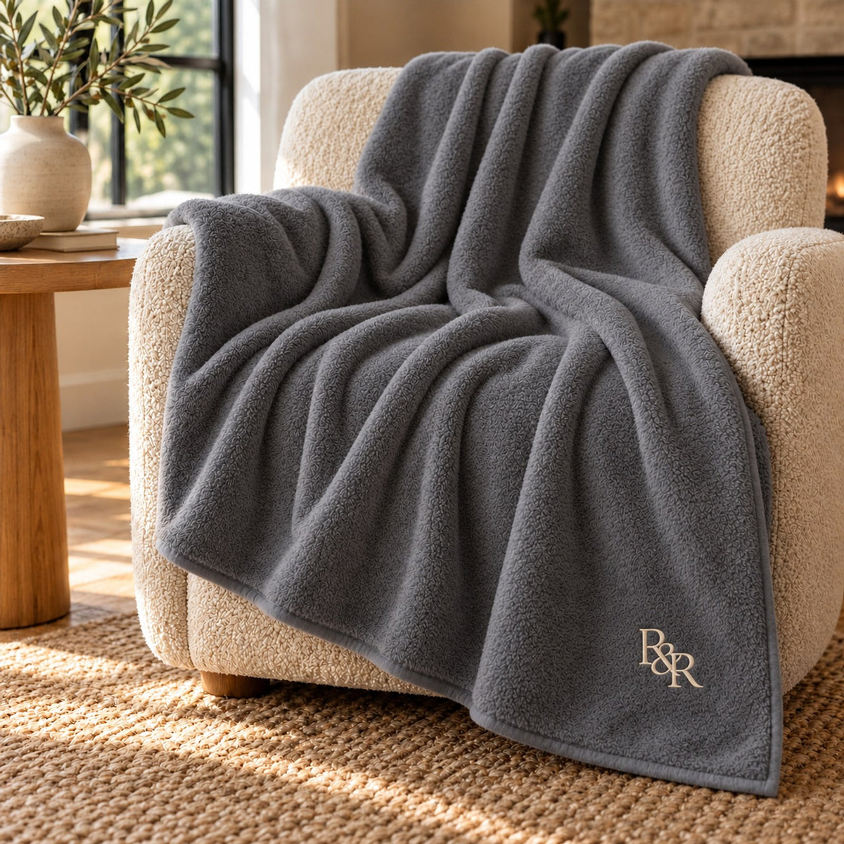 Cream Monogram Embroidered Plush Throw in Shadow Grey, styled at home