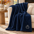 Pumpkin Embroidered Plush Throw in Navy, styled at home