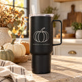 Black 40 oz tumbler with handle engraved with a pumpkin