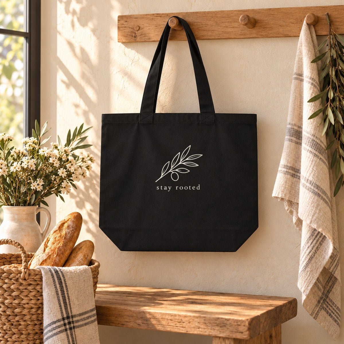 Stay Rooted Olive Branch Organic Cotton Tote in Black, styled at home